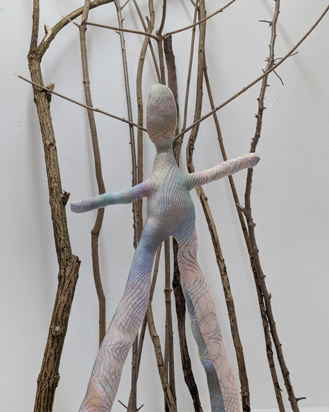 Tejzt – Hektriun Shikking, textile Figurenskulptur zwischen Ästen, 2026