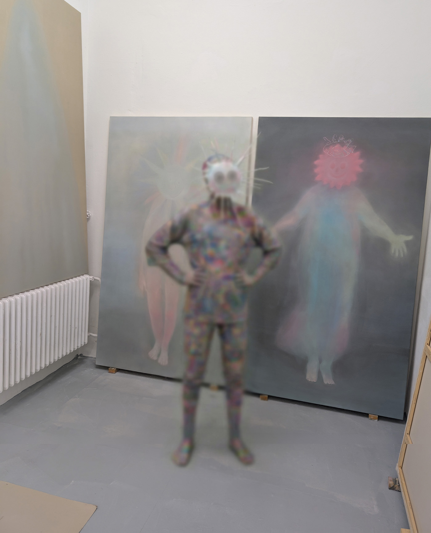 Tejzt — studio view with two large blurred paintings and a masked figure in pastel suit (RG25, 2025)
